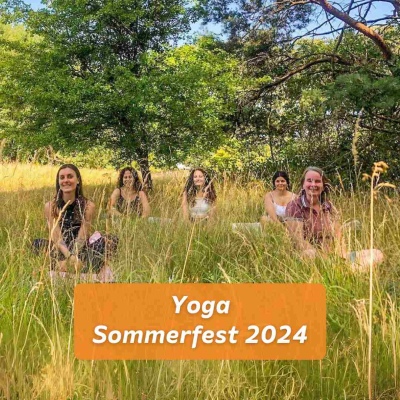 Eine kleine Gruppe von Menschen sitzt im hohen Gras auf Yogamatten und schaut in Richtung der Kamera. Darunter der Text „Yoga Sommerfest 2024“ vor orangem Hintergrund.