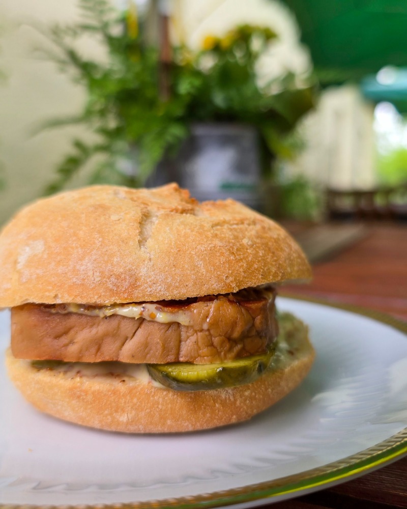 Ein veganes "Leberkeese"-Brötchen auf einem Teller